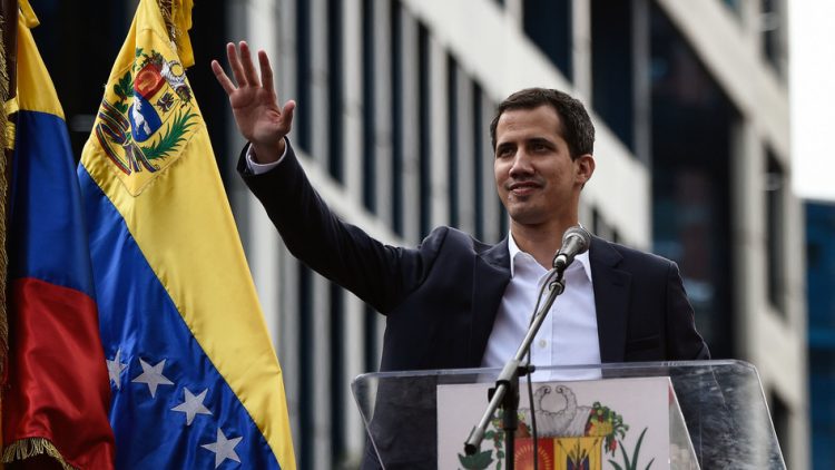 Venezuela's National Assembly head Juan Guaidó waves during a mass opposition rally, during which he declared himself the country's acting president on Jan. 23