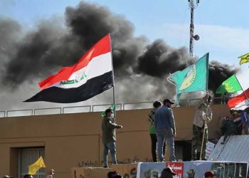 Smoke rises after pro-Iranian militiamen and their supporters set a fire in front of the U.S. embassy in Baghdad, Iraq, Wednesday, Jan. 1, 2020. U.S. troops have fired tear gas to disperse hundreds of pro-Iran militiamen and other protesters who were gathered for a second day outside the American Embassy compound in Baghdad. (AP Photo/Khalid Mohammed)