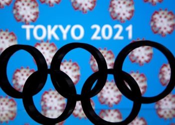 A 3D printed Olympics logo is seen in front of displayed  "Tokyo 2021"  words in this illustration taken March 24, 2020. REUTERS/Dado Ruvic