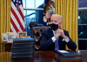 President Joe Biden waits to sign his first executive order in the Oval Office of the White House on Wednesday, Jan. 20, 2021, in Washington. (AP Photo/Evan Vucci)