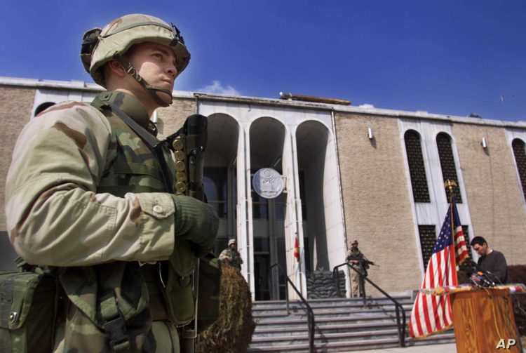 A U.S. marine, name not given, guards the entrance of the U.S. embassy in Kabul, prior to a news conference by Zalmy Khalilzad, U.S. Special Envoy in Afghanistan Sunday Feb. 24, 2002. (AP Photo/Lefteris Pitarakis)