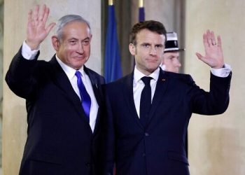 Israel's Prime Minister Benjamin Netanyahu (L) and France's President Emmanuel Macron (R) wave prior to a working dinner at the Presidential Elysee Palace in Paris on February 2, 2023. (Photo by Ludovic MARIN / AFP)