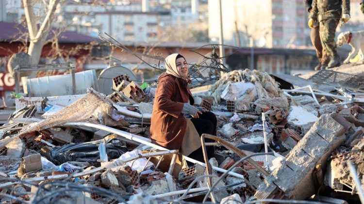 A woman sits on the rubble of a destroyed building in Kahramanmaras, southern Turkey, a day after a 7.8-magnitude earthquake struck the country's southeast, on February 7, 2023. - Rescuers in Turkey and Syria braved frigid weather, aftershocks and collapsing buildings, as they dug for survivors buried by an earthquake that killed more than 5,000 people. Some of the heaviest devastation occurred near the quake's epicentre between Kahramanmaras and Gaziantep, a city of two million where entire blocks now lie in ruins under gathering snow. (Photo by Adem ALTAN / AFP) (Photo by ADEM ALTAN/AFP via Getty Images)