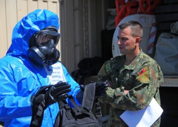 An Albanian chemical soldier observes the process to decontaminate a reconnaissance observer during hands-on training by Soldiers from the 50th Chemical Company, New Jersey National Guard, May 18, 2023, at Komanda e Forces Tokesore in Zall-Herr, Albania. The New Jersey Guardsmen are conducting annual training in Albania to teach and mentor the Albanian military as they prepare to participate in the Dynamic Employment of Forces to Europe for NATO Deterrence and Enhanced Readiness 2023 exercise. DEFENDER 23 i