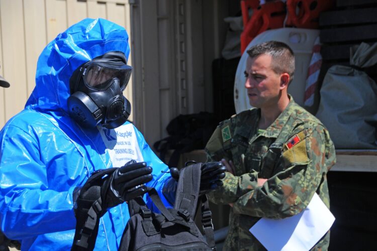 An Albanian chemical soldier observes the process to decontaminate a reconnaissance observer during hands-on training by Soldiers from the 50th Chemical Company, New Jersey National Guard, May 18, 2023, at Komanda e Forces Tokesore in Zall-Herr, Albania. The New Jersey Guardsmen are conducting annual training in Albania to teach and mentor the Albanian military as they prepare to participate in the Dynamic Employment of Forces to Europe for NATO Deterrence and Enhanced Readiness 2023 exercise. DEFENDER 23 i