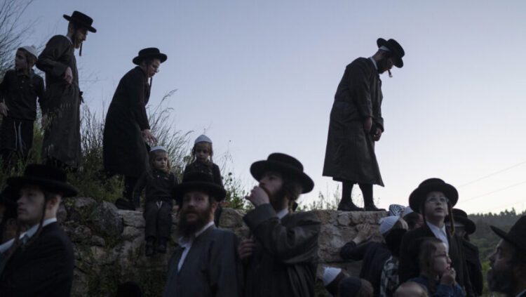 Ultra-Orthodox Jewish men and youth gather to collect water to make matzoh, a traditional handmade unleavened bread for the holiday of Passover, during the Maim Shelanu ceremony at a mountain spring in the outskirts of Jerusalem, Sunday, April 21, 2024. (AP Photo/Leo Correa)