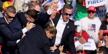 Republican presidential candidate and former U.S. President Donald Trump is assisted by U.S. Secret Service personnel after gunfire rang out during a campaign rally at the Butler Farm Show in Butler, Pennsylvania, U.S., July 13, 2024. REUTERS/Brendan McDermid