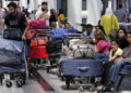 Travelers sit next to their luggage at the departure terminal of the Rafik Hariri International Airport in Beirut, Lebanon, Tuesday, Aug. 20, 2019. Lebanese Prime Minister Saad Hariri inaugurated new measures at the country's main international airport that aim to end crowding at the departure lounge. Passengers will check in their luggage that will later be scanned by the sophisticated scanners. (AP Photo/Bilal Hussein)/OTK/19232458530751//1908201510